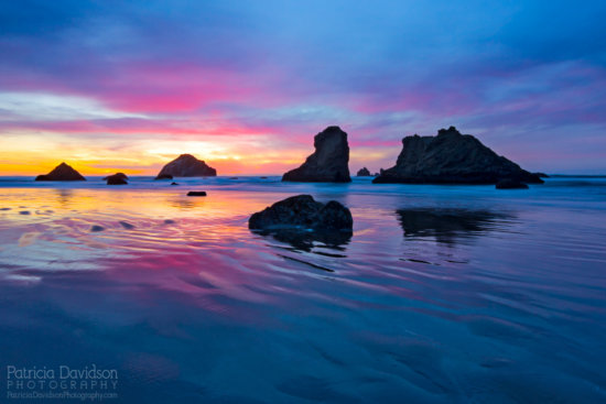 A colorful sunset in Bandon, Oregon. Face Rock and other sea stacks dot the lanscape.